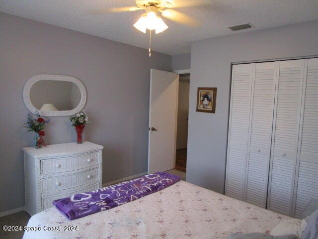 carpeted bedroom featuring ceiling fan and a closet