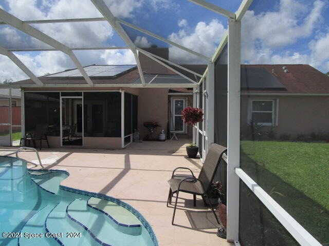 rear view of house featuring a patio area, a lanai, and a fenced in pool