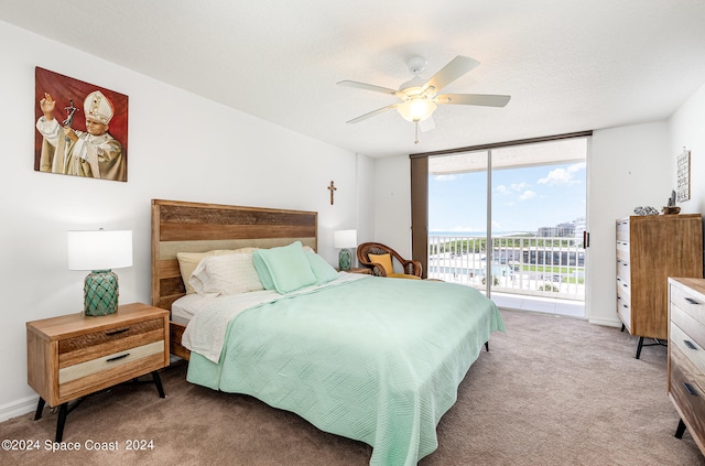 carpeted bedroom featuring a textured ceiling, access to exterior, ceiling fan, and floor to ceiling windows