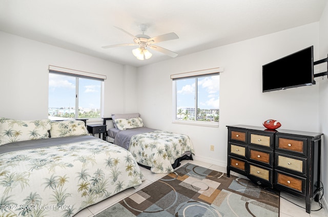 tiled bedroom with multiple windows and ceiling fan