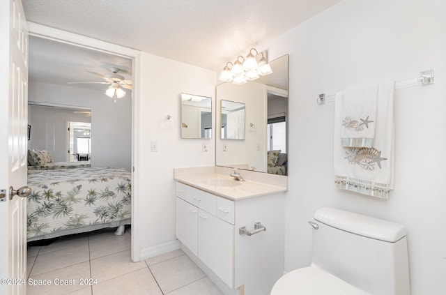 bathroom featuring toilet, tile patterned floors, ceiling fan with notable chandelier, vanity, and a textured ceiling