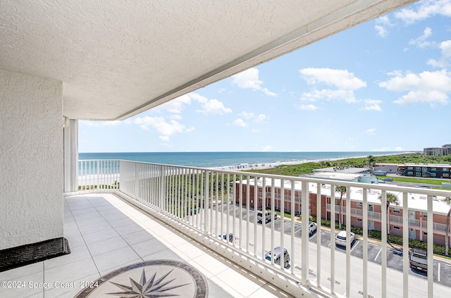 balcony featuring a water view and a beach view