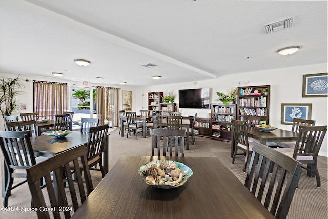 dining space with a textured ceiling and carpet floors