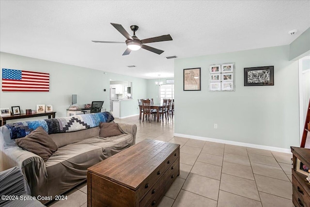 tiled living room featuring ceiling fan and a textured ceiling