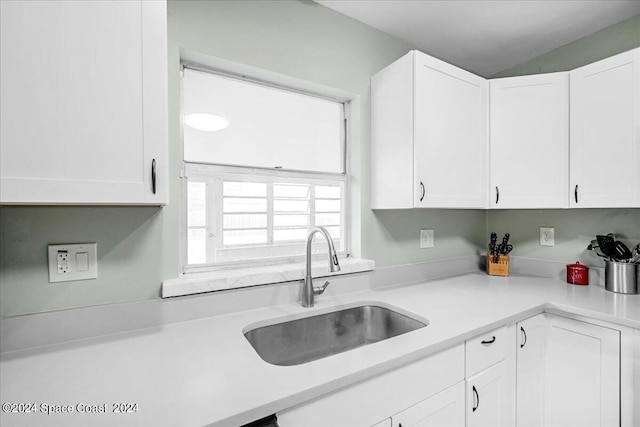 kitchen featuring white cabinetry and sink