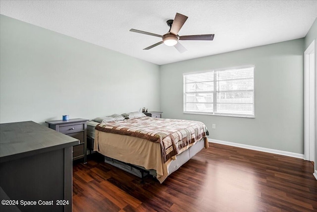 bedroom with dark hardwood / wood-style flooring, ceiling fan, and a textured ceiling