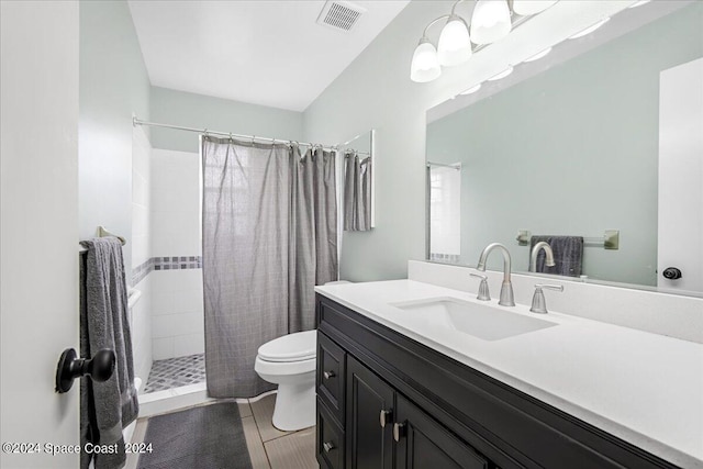 bathroom with tile patterned flooring, walk in shower, toilet, and vanity