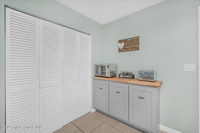 interior space with butcher block counters and light tile patterned floors