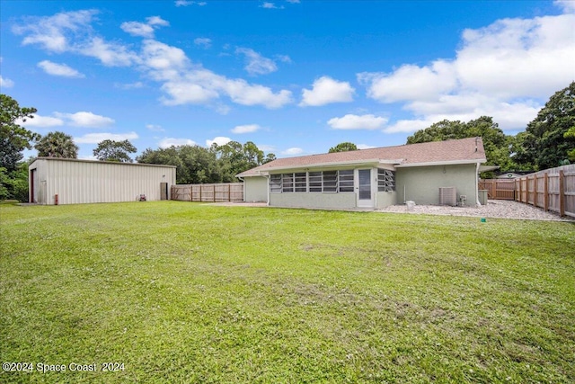 rear view of property with a yard and a sunroom