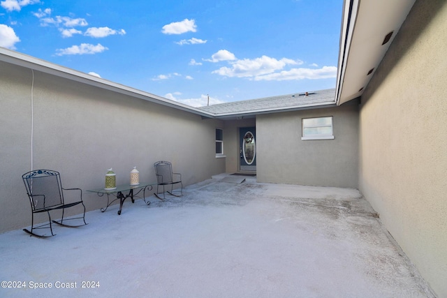 property entrance with a patio area and stucco siding