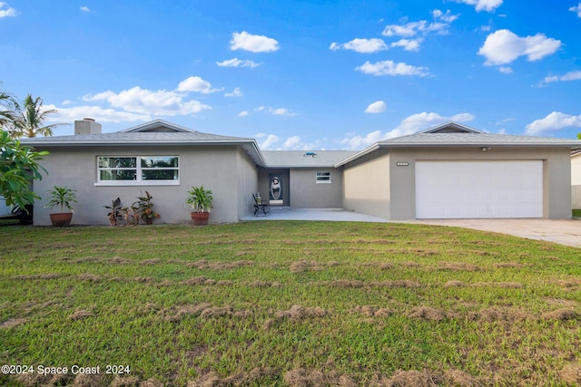 ranch-style home with a chimney, stucco siding, an attached garage, a front yard, and driveway