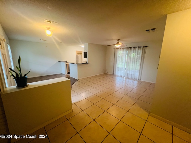 tiled spare room featuring ceiling fan