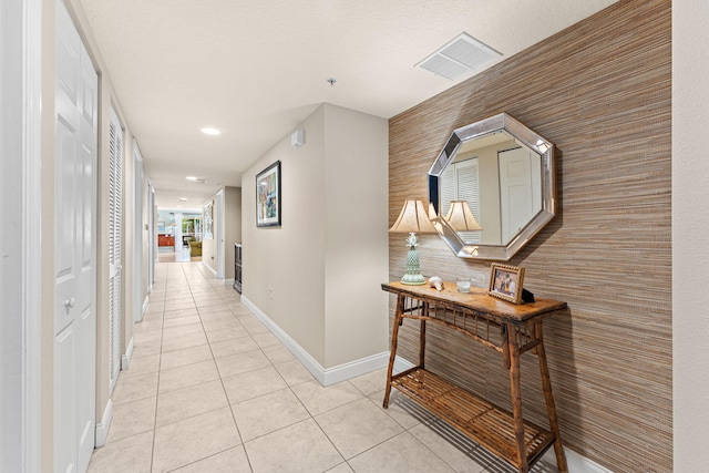 hallway with recessed lighting, visible vents, baseboards, and light tile patterned floors