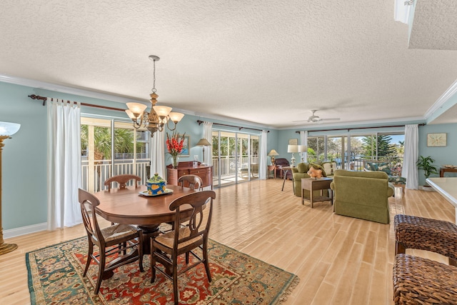 dining area with crown molding, light wood finished floors, a textured ceiling, baseboards, and ceiling fan with notable chandelier