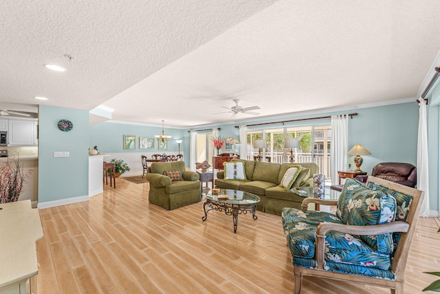 living room with light wood-style flooring, baseboards, a textured ceiling, and ceiling fan with notable chandelier