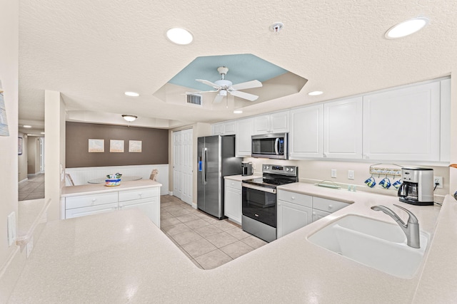 kitchen featuring a sink, visible vents, white cabinetry, appliances with stainless steel finishes, and a raised ceiling