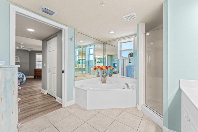 ensuite bathroom featuring a stall shower, a garden tub, visible vents, and tile patterned floors