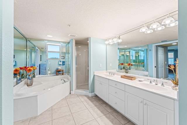 bathroom with a stall shower, a garden tub, a sink, and visible vents