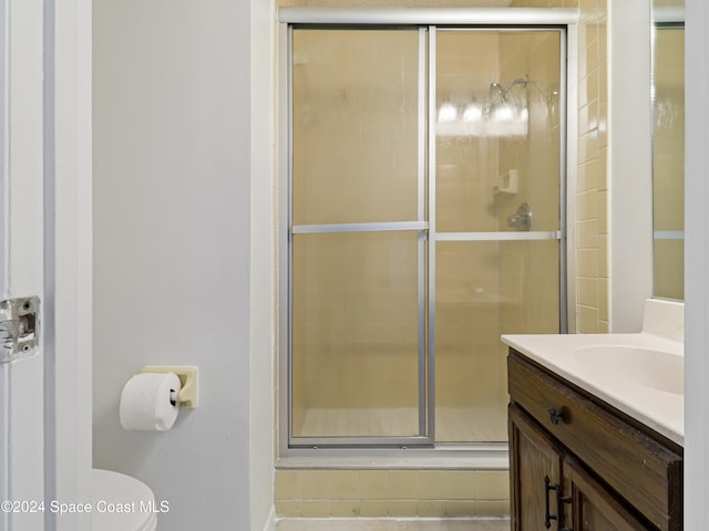 bathroom with vanity, an enclosed shower, and toilet