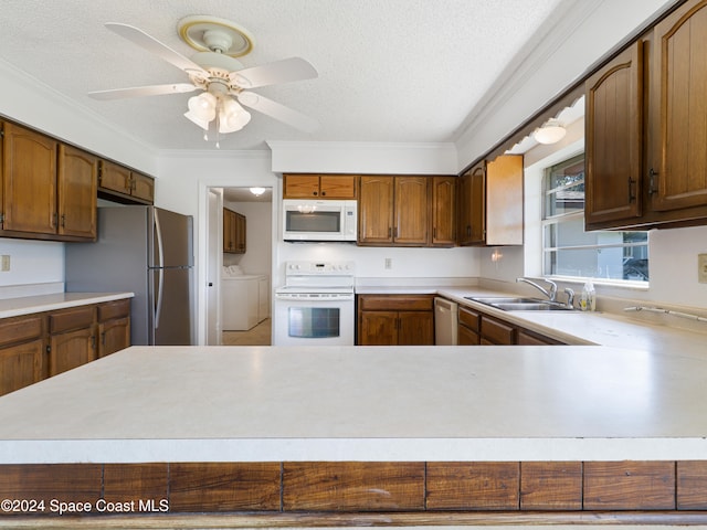 kitchen with a textured ceiling, ornamental molding, sink, and appliances with stainless steel finishes