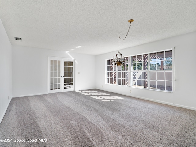 interior space with a chandelier, french doors, a textured ceiling, and carpet