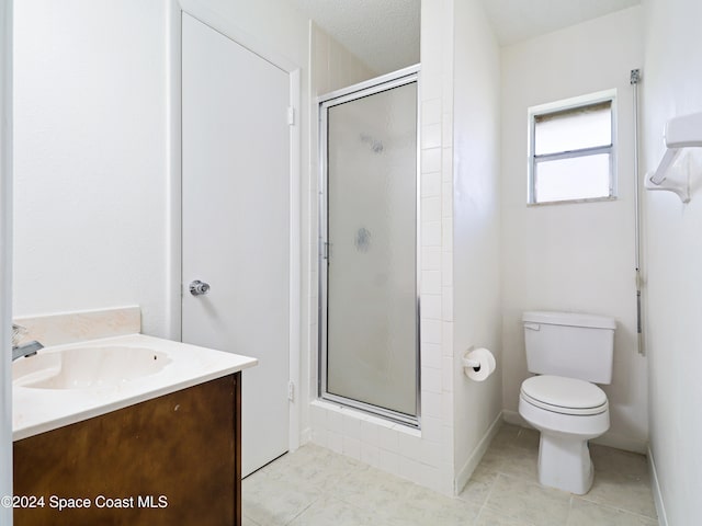 bathroom with tile patterned floors, vanity, a textured ceiling, toilet, and a shower with shower door