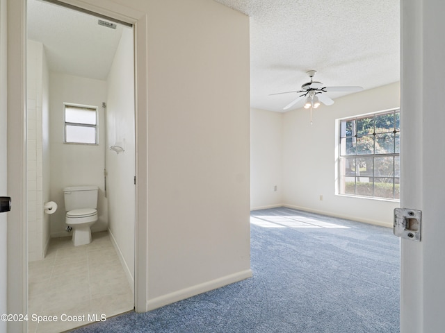 interior space with a textured ceiling and ceiling fan