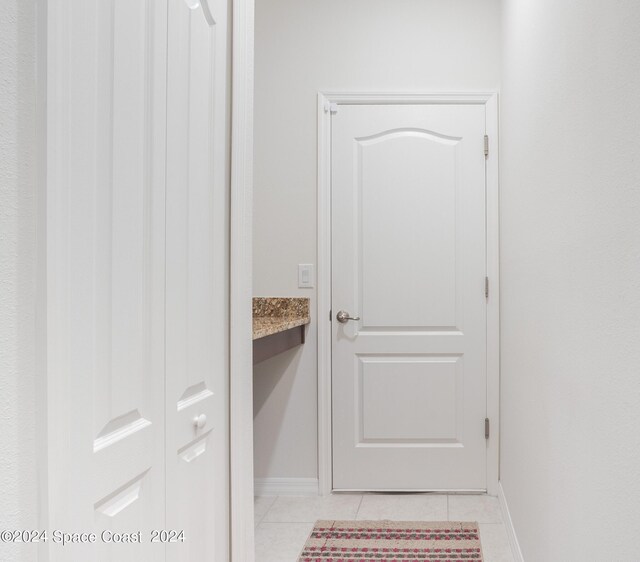 hall featuring light tile patterned floors