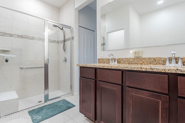 bathroom with tile patterned flooring, vanity, and a shower with door