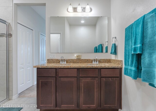 bathroom with walk in shower, tile patterned flooring, and vanity