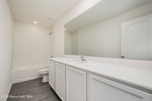 full bathroom featuring visible vents, toilet, wood finished floors, vanity, and washtub / shower combination