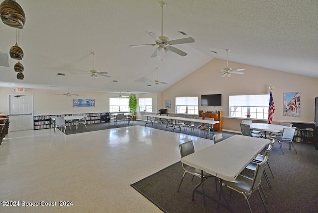 dining area with high vaulted ceiling and a textured ceiling