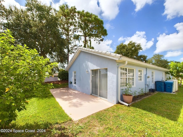 back of property featuring a yard and a patio