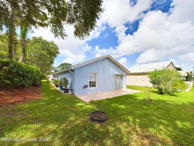 view of side of home with a yard and a patio