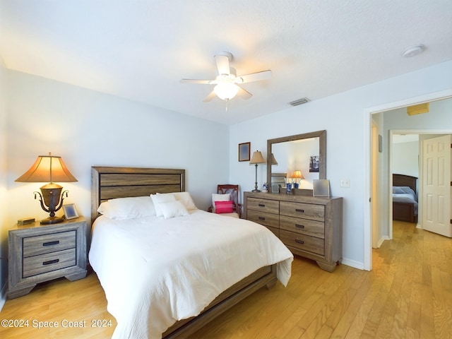 bedroom with light hardwood / wood-style floors and ceiling fan