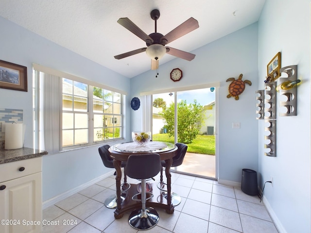 tiled dining room with lofted ceiling and ceiling fan