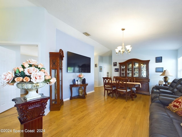 living room featuring a chandelier and light wood-type flooring