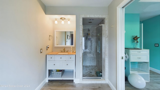 bathroom featuring a shower with shower door and vanity