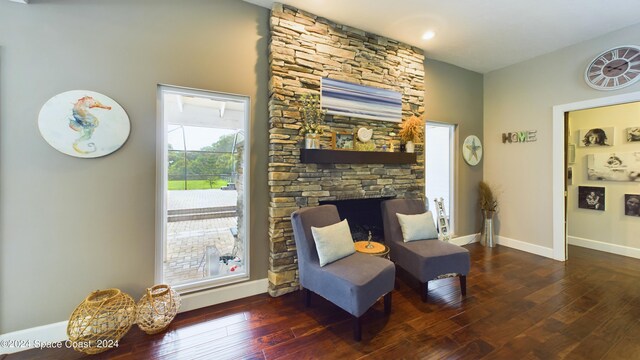 living area with a fireplace and dark hardwood / wood-style flooring