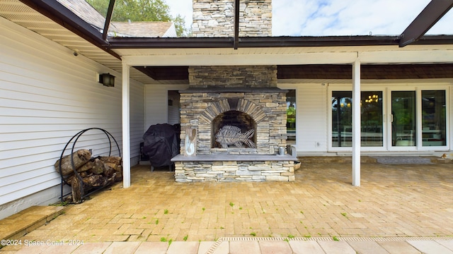 view of patio / terrace with a grill and an outdoor stone fireplace