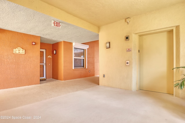 empty room featuring carpet and a textured ceiling