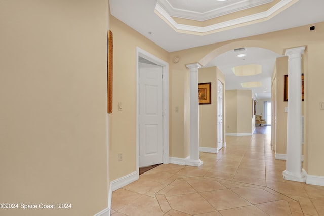 hall with light tile patterned floors, crown molding, and ornate columns