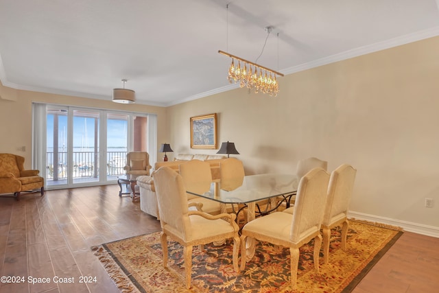 dining area featuring ornamental molding, a chandelier, and dark hardwood / wood-style flooring