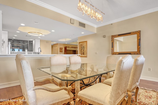 dining room featuring crown molding, hardwood / wood-style flooring, and a chandelier