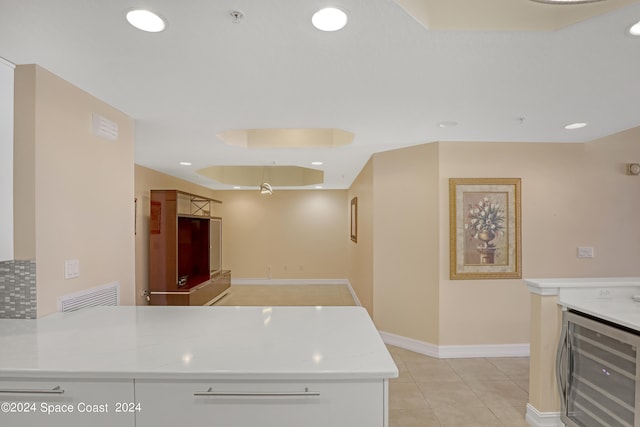 kitchen with light stone counters, beverage cooler, and light tile patterned floors