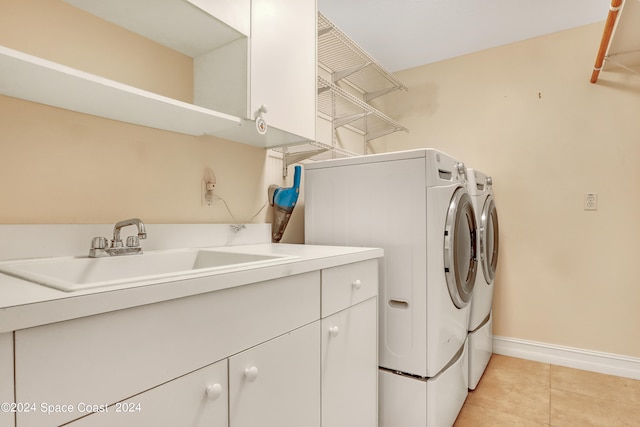 washroom featuring light tile patterned floors, sink, cabinets, and washing machine and dryer