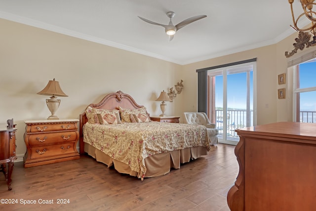 bedroom with multiple windows, access to outside, wood-type flooring, and ceiling fan