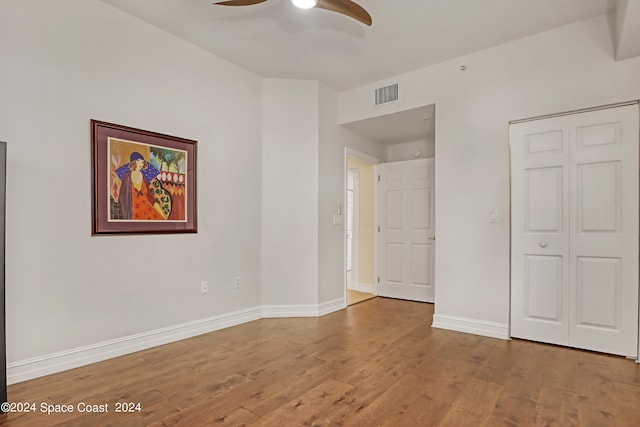 unfurnished bedroom featuring ceiling fan, a closet, and hardwood / wood-style flooring