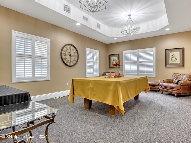 interior space featuring a tray ceiling, a notable chandelier, and multiple windows