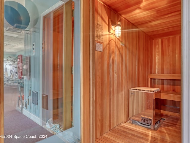 view of sauna with wood ceiling and wood walls